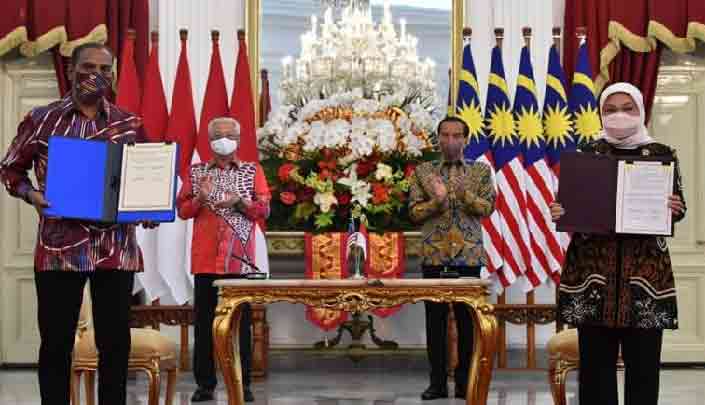 Perdana Menteri Malaysia Ismail Sabri Yaakob (belakang, kiri) dan Presiden Indonesia Joko Widodo (belakang, kanan) menyaksikan penandatanganan Nota Kesepahaman tentang ketenagakerjaan dan perlindungan pekerja migran Indonesia di Malaysia di Istana Merdeka, Jakarta pada 1 April 2022 [Foto: Bernama]